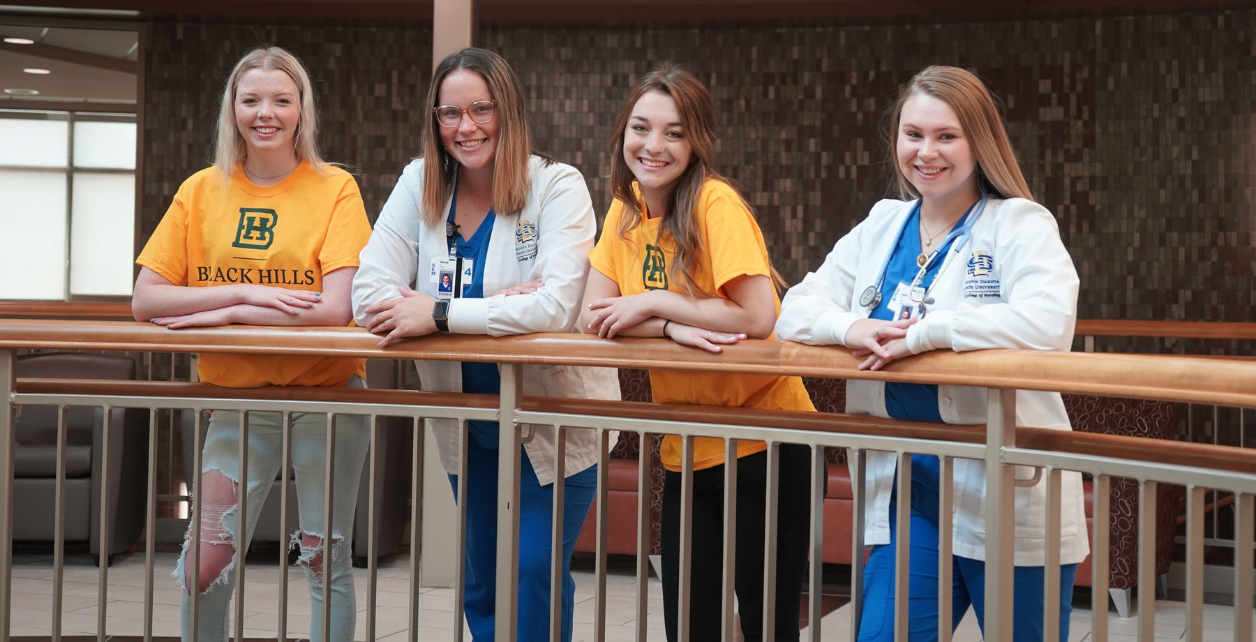 Group of 4 females in SDSU apparel